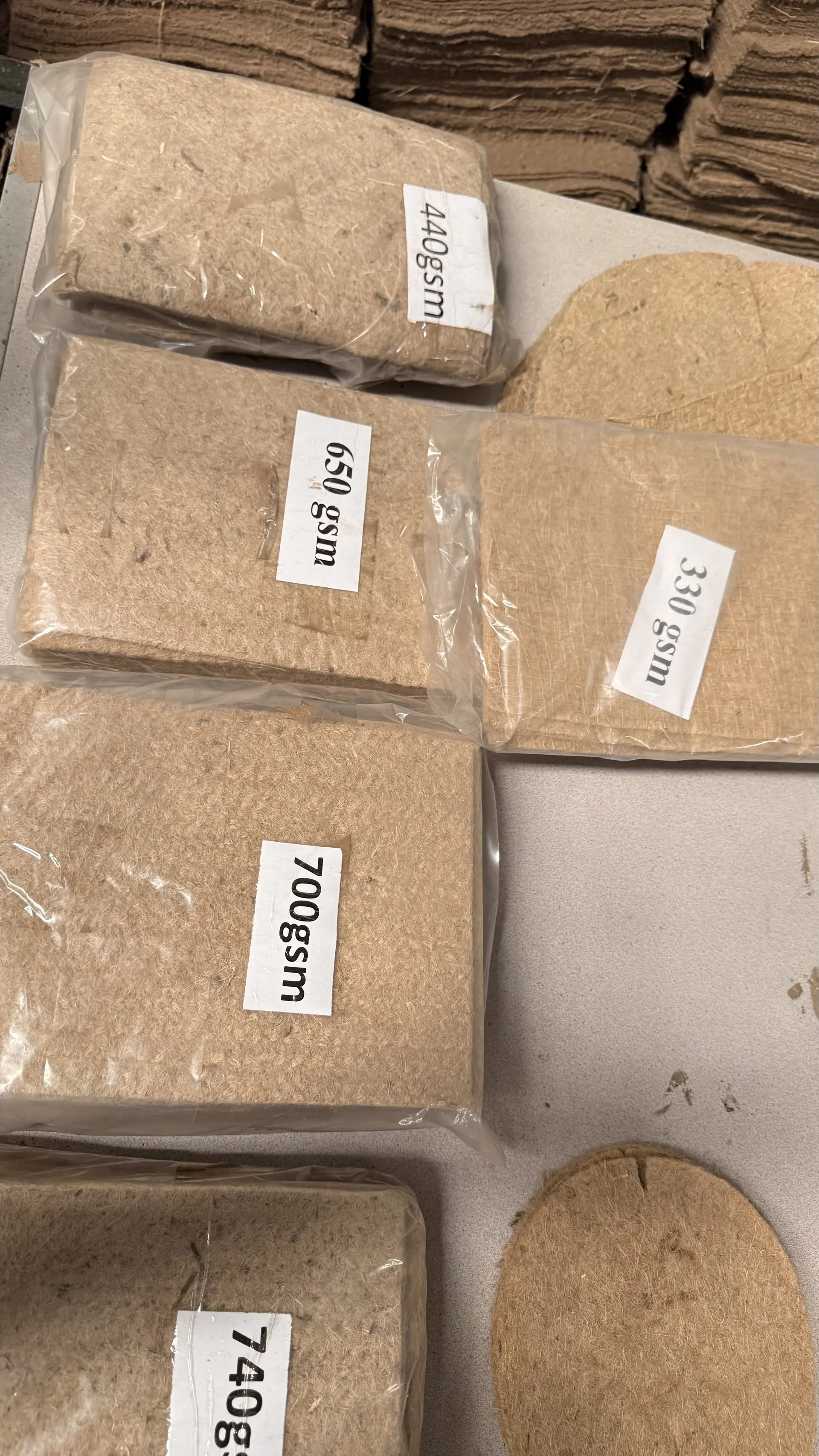 Labelled physical GSM sample bricks — 330, 440, 650, 700, 740 g/m² — bagged for buyer approval